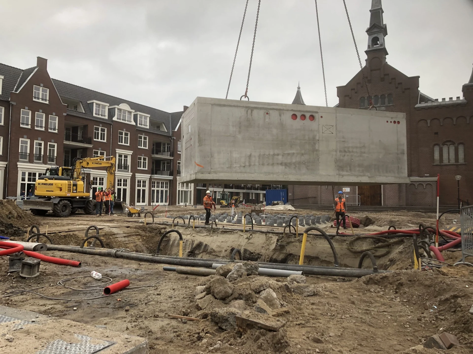 De betonnen combikelder wordt met een kraan in de bouwput geplaatst op het Kerkplein in Hoogeveen