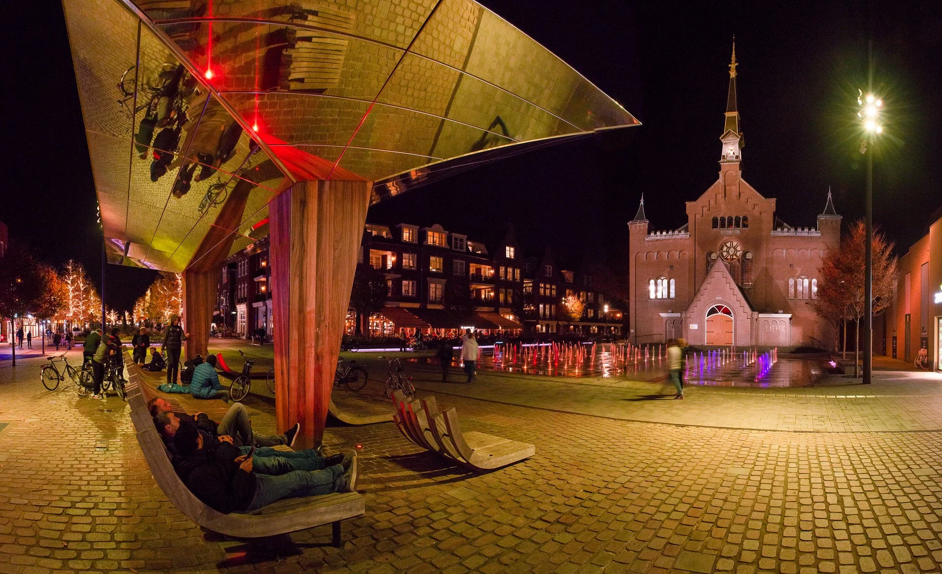 De spiegelkraan met luifel en de kerk op het Kerkplein in Hoogeveen in de avond