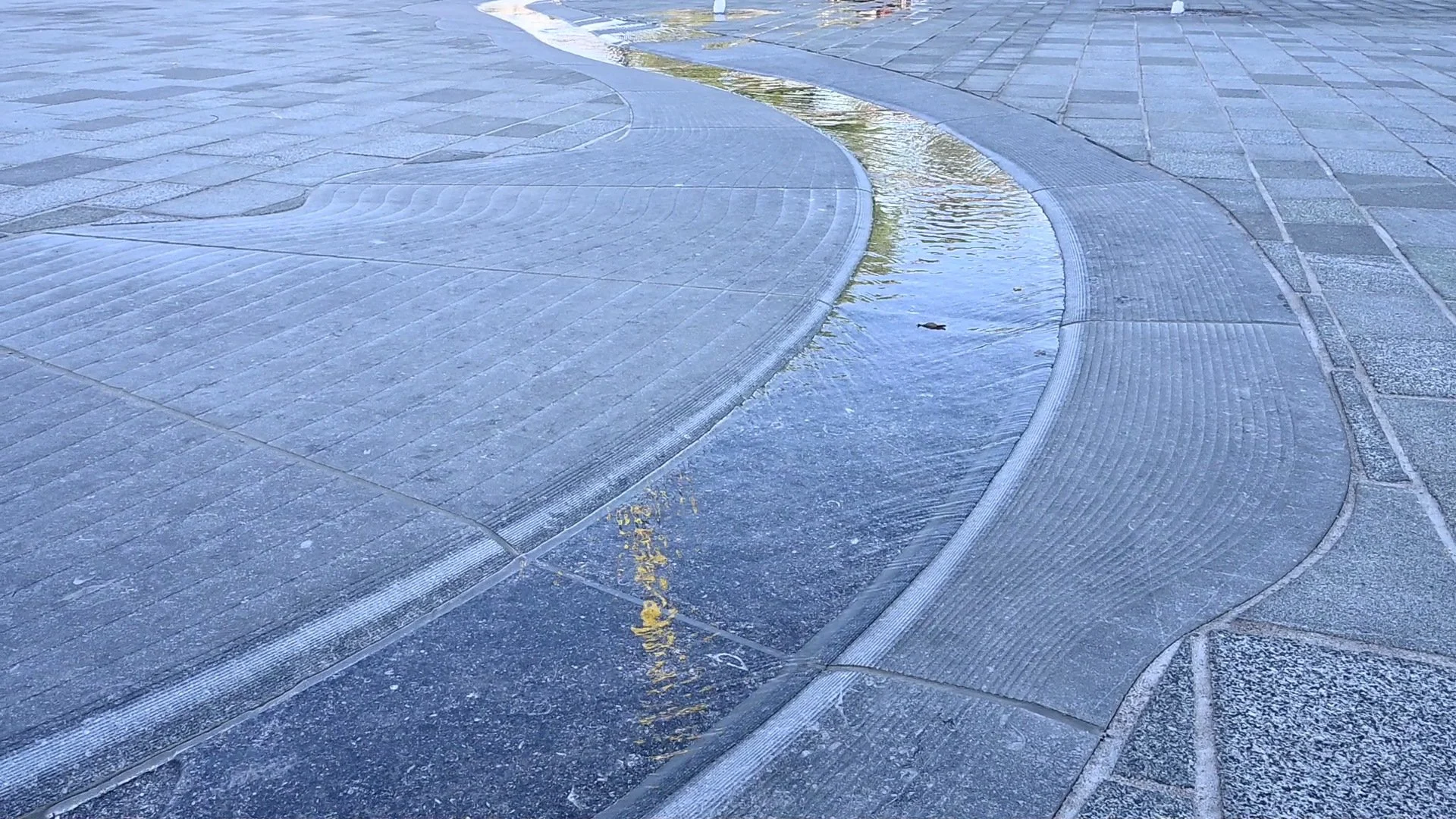Fonteininstallatie Maasgoot Cuijk 2 Gefreesd reliëf in hardsteen langs de waterloop op het Louis Jansenplein in Cuijk bij schemering