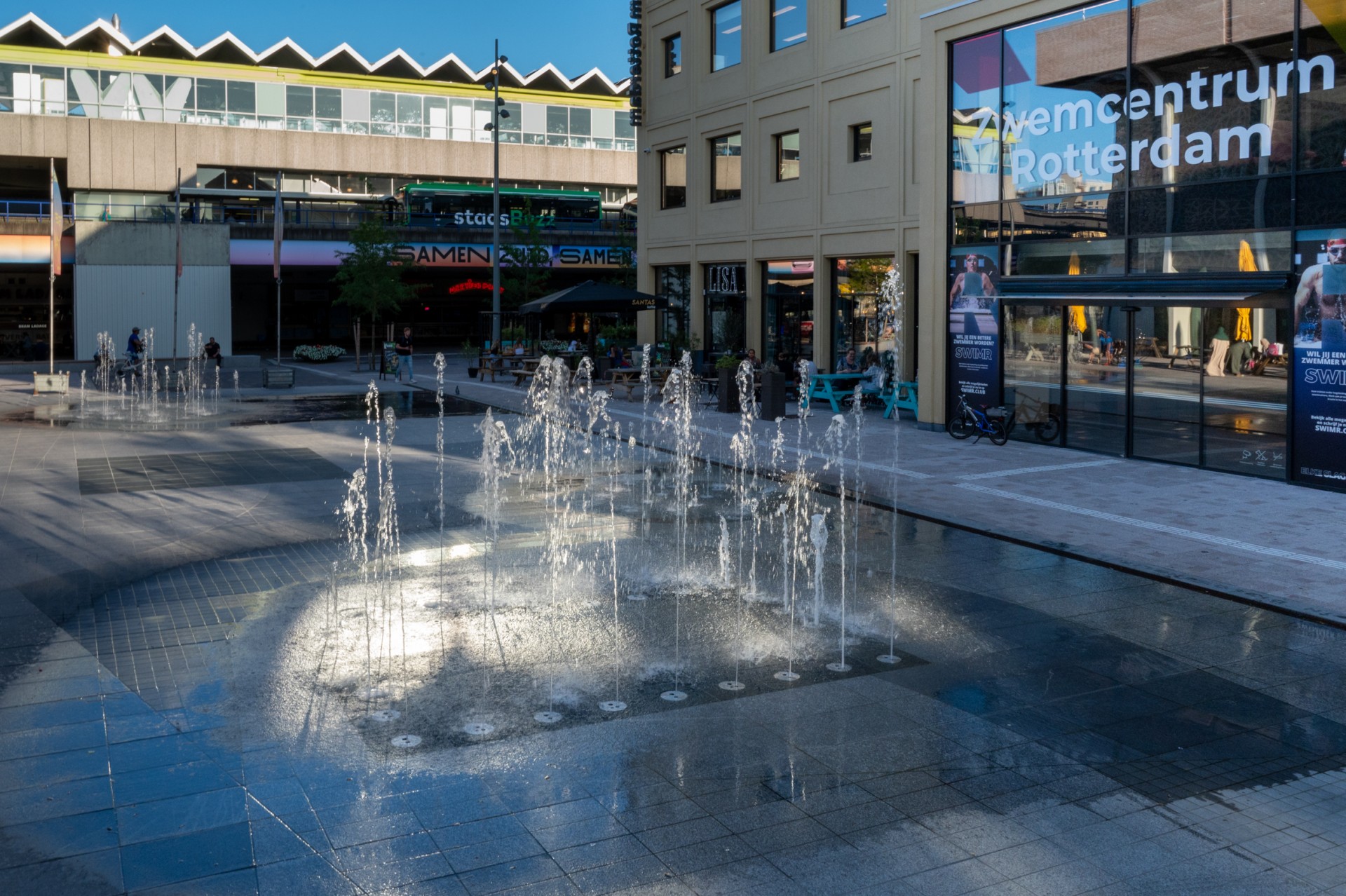 Fontein Annie MG Schmidt plein Rotterdam. Hart van Zuid Rotterdam. Natuursteen in meerdere soorten en kleuren maken een abstract pallet op de vloer. Fonteinen en nevel maken het spectakel compleet.